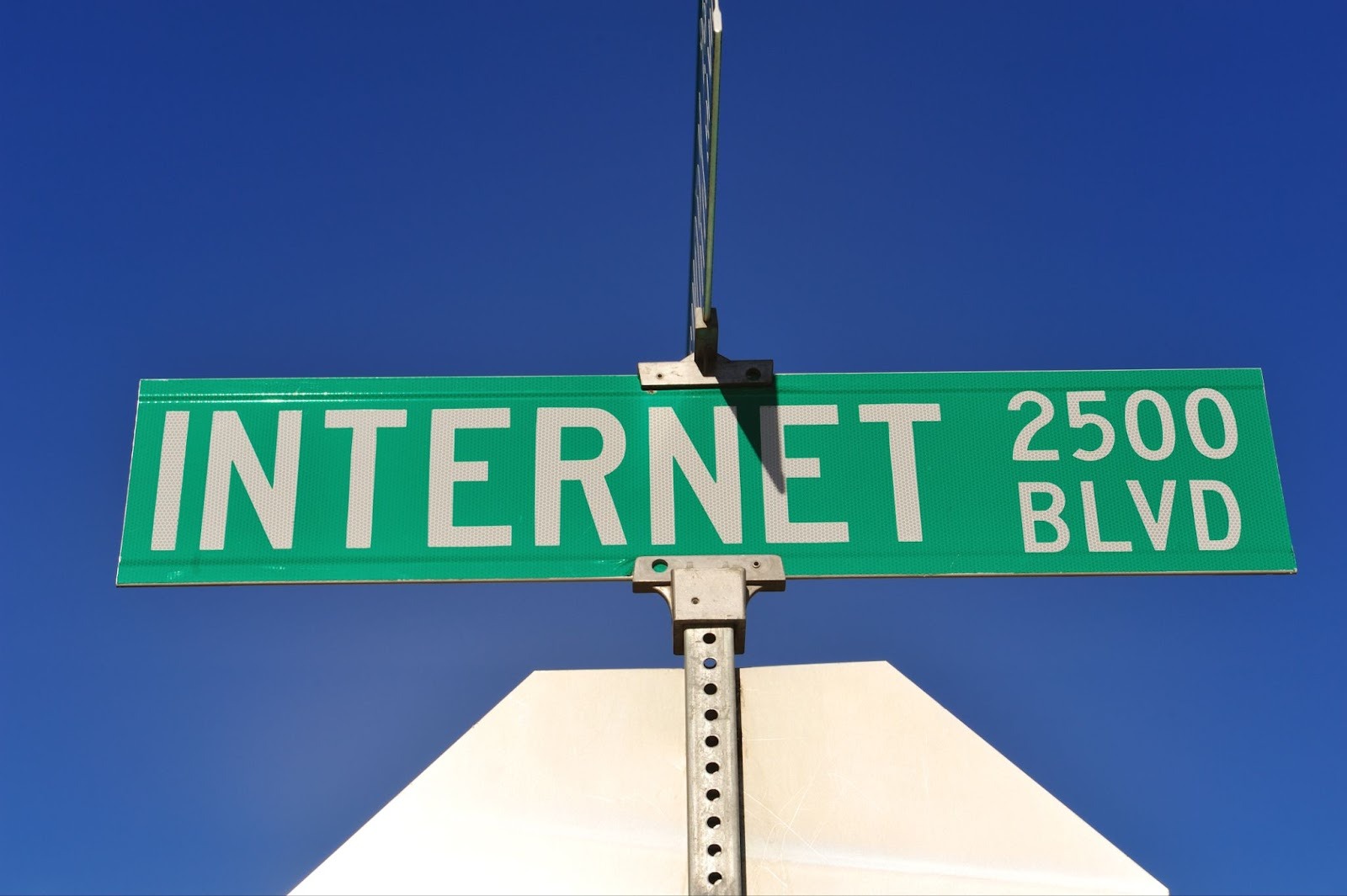 Green street sign reading 'Internet Blvd 2500' against a clear blue sky